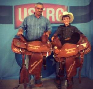 Camden Hoelting, right, Olpe, and his heeling partner, Bruce Grinstead, Rose Hill, showed their championship saddles they collected, along with $6,650, for roping and stretching four steers in 38.43 seconds, to win the No. 10 division at the United States Team Roping Championships in Hutchinson. by Frank J Buchman