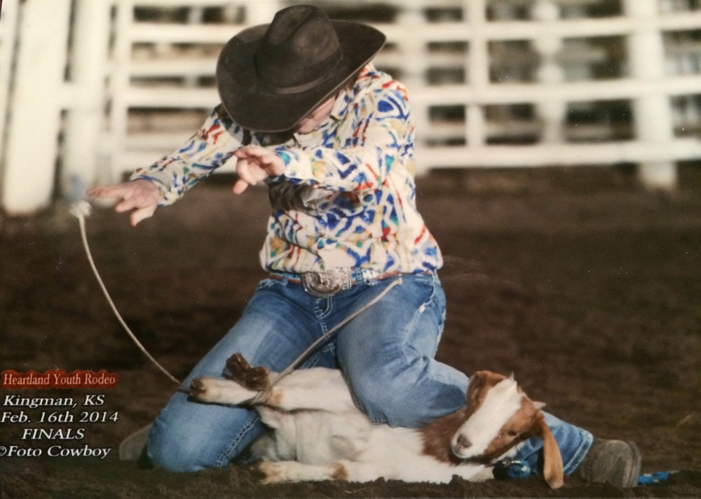 As all-around cowgirl, Michaela Peterson of Council Grove hands in the air completes her goat tying run during the February 16, 2014, Heartland Youth Rodeo Finals at Kingman. (Kent Kerschner Photography, fotocowboy.com)