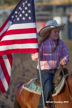 Karlie Gibb, Strong City, daughter of Kyle and Jenna Gibb, and granddaughter of Kim and Lana Reyer, carried ole glory in the inspirational grand entry for the Flint Hills Bull Blowout at Strong City. (Photo by Kent Kerschner Photography “Foto Cowboy.”)