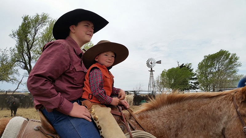 Now here’s a cowboy team, Brayden Krepps with little brother Caleb on front during a spring ranch branding.