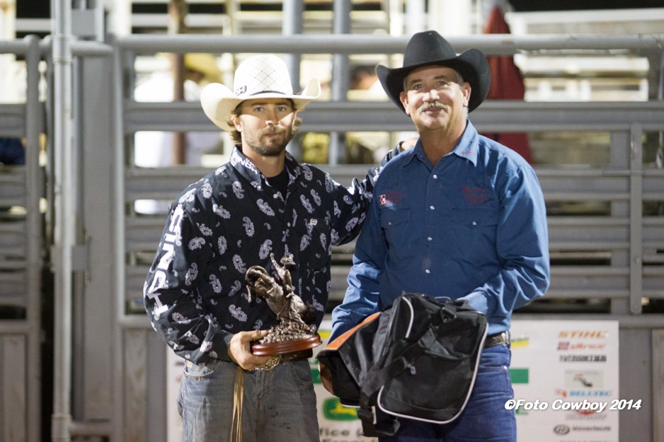 Kim Reyer, of Reyer’s Country Store and Flint Hills Genetics, presented Cooper Kanngiesser of Attica awards as champion at last year’s Flint Hills Bull Blowout, third time in a row for that achievement, and a goal the cowboy bull rider intends to match on Saturday night, Sept. 12, in Strong City. (Photo by Kent Kerschner Photography – “Foto Cowboy.”)