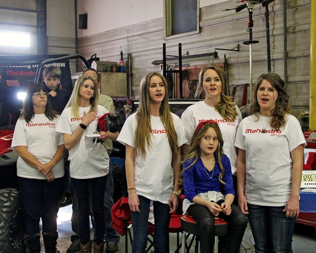The Morris Singers presented a most inspirational rendition of the national anthem as part of the Military Appreciation Day at Heinen Repair Service, Valley Falls, before presentation of new Mahindra XTV to Army Lt. Col. Candy Smith winner of the Mahindra Tribute To The Brave Giveaway. Diane and Chantel Heinen pay tribute as Cierra, Cheyanne and Charity Morris, along with Ava Scallorn-Morris sing The Star Spangled Banner. (Photo courtesy of Lizzie Esparza, LE Photography.)